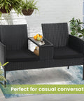 Two Seat Outdoor Patio Loveseat With Table In Black Wicker Rattan Outdoor Set With Washable Cushion Covers Weatherproof Garden Lounge Furniture For Backyard Lawn And Porch, displayed on a patio with plants.