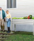 Two Pack Galvanized Raised Garden Bed With Legs For Easy No Bending Gardening filled with vegetables, on backyard patio.