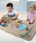 Children playing with On The Go Kid Friendly Race Track Table With 2-Sided Play Surface For Cars And Trains, Portable No Assembly Toy Table For Ages 3 4 5 6 7, Made In USA, Great For Playrooms And Living Rooms.