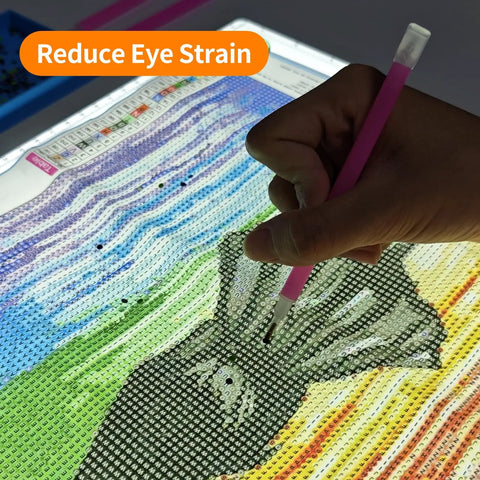 Using A2 Magnetic LED Light Pad for Diamond Painting on a colorful pattern, demonstrating precise application of beads.