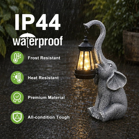 Elephant Statue Garden Decor With East Asian Charm featuring a solar lantern, IP44 waterproof, in warm gray tone during rain.