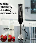 Game Changer 350 Watt Hand Blender With Beaker And Whisk Attachment Providing Dual Speed Control Splash Resistant Shaft Stainless Steel Blades For Smooth Purees on a kitchen counter with milk and strawberries