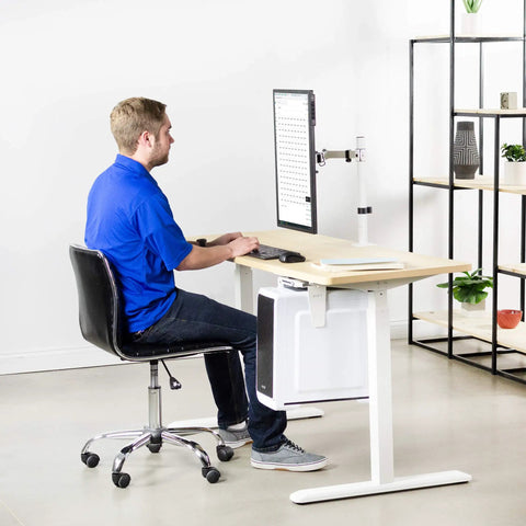 Man using Heavy Hitter Single Monitor Desk Mount with smooth tilt and swivel for a 32-inch monitor at a modern workspace.