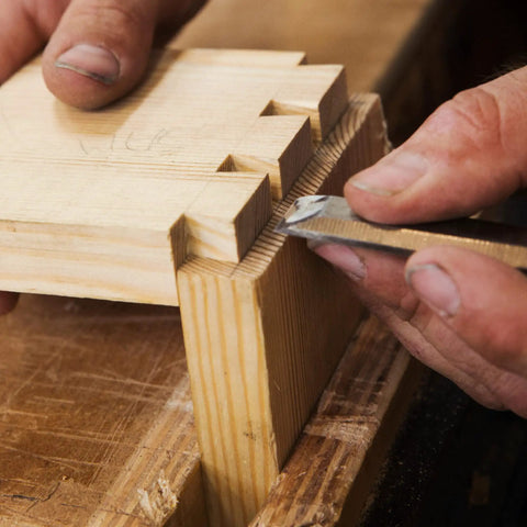 Using Built Tough 4 Piece Bench Chisel Set For Serious Woodworkers Carved From Top Shelf Chrome Vanadium Steel to refine wood joints.