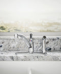 Jolt Swing Spout With Integrated Side Spray faucet in chrome, mounted on marble countertop, bath tap view