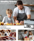No Sweat Compact Food Dehydrator For Crafting Homemade Beef Jerky Crispy Banana Chips Dried Oregano Leaves And Handcrafted Puppy Bites Saves Precious Counter Room Perfect For Studio Apartments And Glamping Shacks in a kitchen setting with two people preparing fruit.