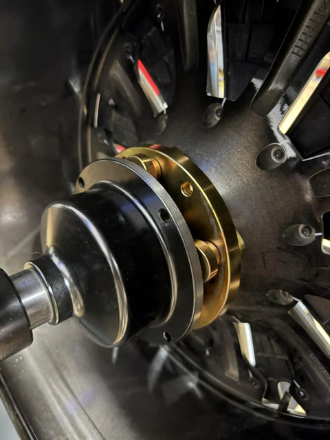 Grip Tight 40mm Shaft Wheel Balancer Adapter With Shop Grade Tire Balancer Clamp mounted on wheel for precise balancing.