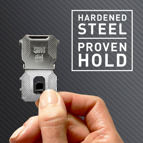 Hand holding Heavy Duty Drywall Picture Hanger That Holds Up To 65 Pounds, Installs In Seconds With A Quick Push, No Tools Required.