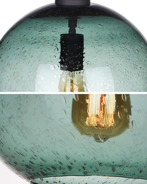 Close-up of hand blown glass pendant light in fir green seeded bubbles, modern farmhouse ceiling fixture interior view.