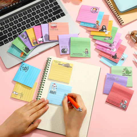 100 Pack Funny Sticky Notes for Work 3 by 3 Inches Sarcastic Self Adhesive Notepads with 25 Designs on desk with laptop and notebook