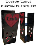 Black custom carved furniture with red heart designs and 'Leah' and 'Bane' engravings, featuring cut-out heart patterns.