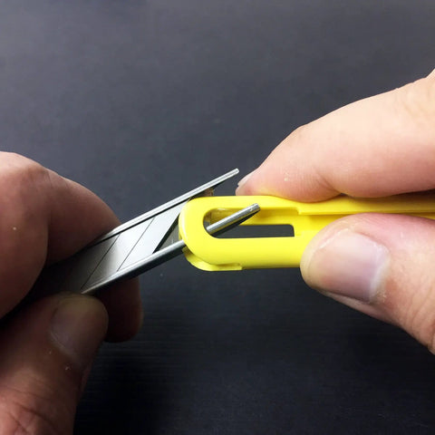 Hands demonstrating the ABS Grip 30-Degree Multi-Blade Cartridge Knife With Five Blade Cartridges, 9mm Snap-Off Utility Knife in use.