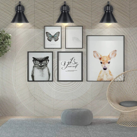 Room with 2 In 1 Plug In Or Hardwired Swing Arm Wall Light Sconce In Industrial Black Finish over framed animal artwork.