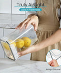 Person holding Stackable Airtight Food Storage Containers With Lids, 24-Piece Plastic Canister Set For Cereal, Dry Food, Flour And Sugar, BPA Free, Includes 24 Labels, Black Kitchen Pantry Organization For A No Mess Kitchen with lemons inside