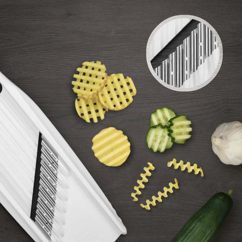 Front view of Börner Wave-Waffle XXL PowerLine white vegetable slicer with crinkle-cut wave blades; zucchini nearby.