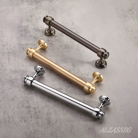 Three straight bar cabinet handles in polished chrome, brushed gold, and matte black finishes displayed on a marble surface.