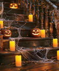 Lit Outdoor Solar Pillar Candles 3x6 Inches Waterproof Rechargeable Flameless Flickering Lights With Dusk To Dawn Sensor For Halloween Garden Patio Porch Decor on steps with jack-o'-lanterns and cobwebs