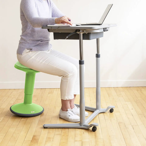 Person sitting on Sitwell Wobble Stool With Cushion Adjustable Height Active Seating For Movement Perfect For Class Or Home Grassy Green