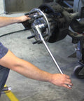 Mechanic using Truck Wheel Stud Installer Tool for 22mm Studs with ratchet on heavy duty vehicle hub in garage