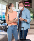 Two people wearing N95 Duckbill Respirator Mask For Everyday Use, ASTM Level 3 Protection, Regular Size, Orange, in an airport.