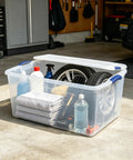 Ginormous 105 Quart Clear Storage Bin With Blue Secure Latch Heavy Duty Plastic Tote For Bulky Seasonal Gear And Bedding Keeps Your Space Spiffy And Makes Organization A Breeze filled with cleaning supplies and towels.
