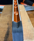 Close-up of Savage Grip 11-Inch Aluminum Torpedo Level With Brightview Technology and four magnets, orange construction on wood surface.