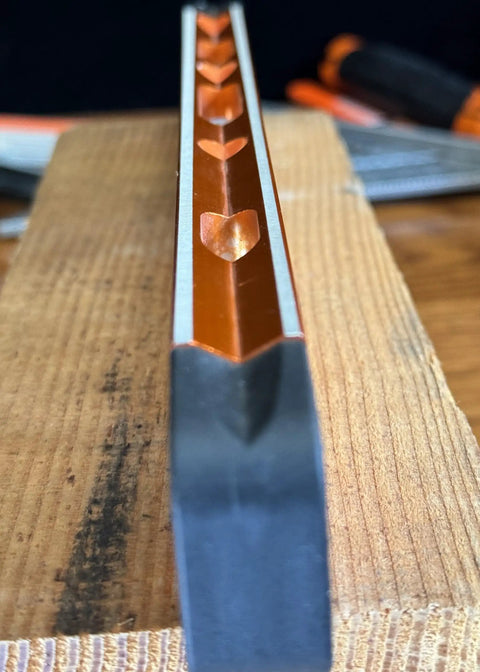 Close-up of Savage Grip 11-Inch Aluminum Torpedo Level With Brightview Technology and four magnets, orange construction on wood surface.