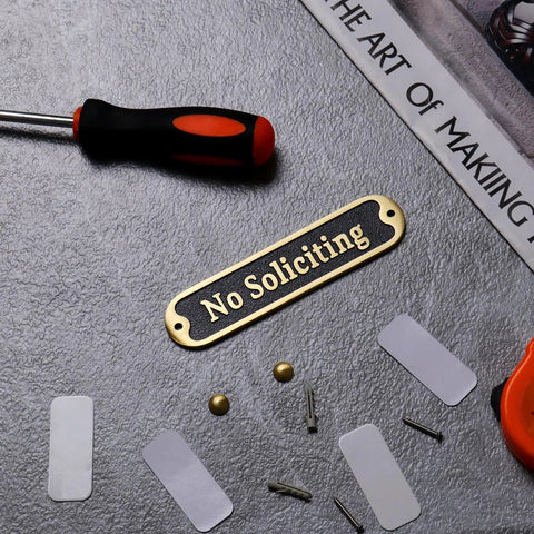 No Soliciting Sign 5 Inch Brushed Matte Brass Finish With Hidden Screws And Nanotape Adhesive shown with installation tools