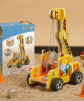 Gravity Crane Science Kit for Kids with lever model on a sandy surface next to the packaging, pulley raised with block.