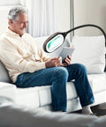 Man reading with LightView Pro Magnifying LED Desk Lamp with flexible gooseneck and 3 in 1 magnifier for eye comfort.