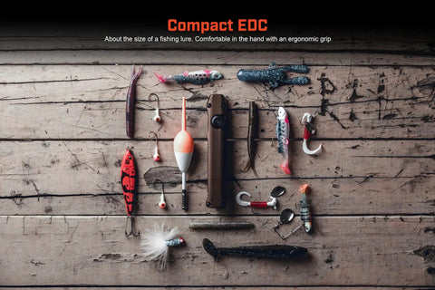 Wedge Beast 1000 Lumen EDC Flashlight With THRO Burst And 300 Lumen Standard Beam, shown with fishing lures on wooden table.