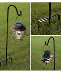 Two Pack Adjustable Shepherd Hooks With Heights Of Thirty One Twenty Four And Sixteen Inches Heavy Duty One Half Inch Thick Black Outdoor Hangers For Lanterns Solar Lights Bird Feeders Planters Wedding Aisles And Yard And Patio Garden Decor, shown installed with a lantern on grass.