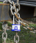 XT Series 44mm Laminated Steel Padlock with Two and Three Eighths Inch Shackle securing a rusty chain outdoors