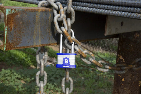 XT Series 44mm Laminated Steel Padlock with Two and Three Eighths Inch Shackle securing a rusty chain outdoors