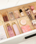 Level Up Your Vanity Game With This 10 Piece Clear Drawer Organizer Set arranged in a tidy vanity drawer with cosmetics and brushes.