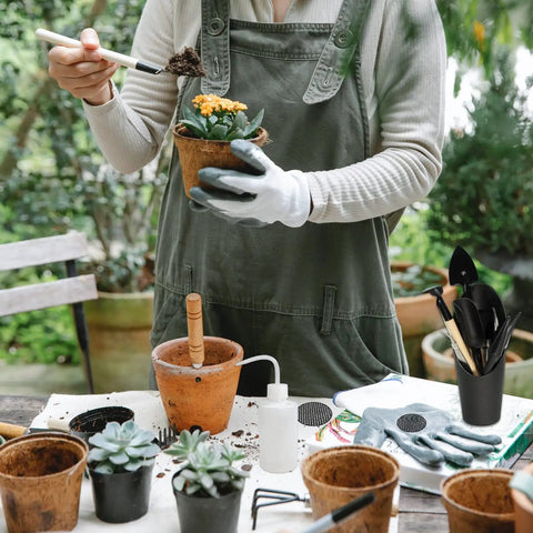 Person using Foldable Plant Repotting Mat With 13 Piece Mini Garden Tools And 30 Pot Hole Mesh Pads, All In One Succulent Tool Kit For Indoor Miniature Fairy Garden Plant Care, Waterproof Oxford Cloth Black