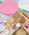 Premium Top Shelf 67 Piece Cookie Decorating Kit With Smooth Turntable Pro Brushes Scribe Needles Non Slip Pads Fresh Piping Bags For Totally Sick Cake Artists, featuring a pink turntable and decorated cookies.