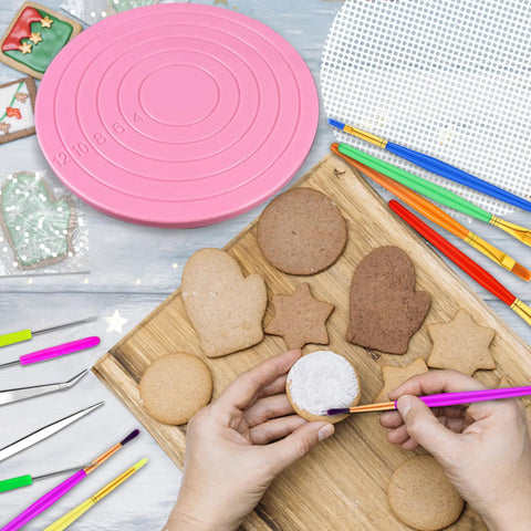 Premium Top Shelf 67 Piece Cookie Decorating Kit With Smooth Turntable Pro Brushes Scribe Needles Non Slip Pads Fresh Piping Bags For Totally Sick Cake Artists, featuring a pink turntable and decorated cookies.