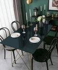 Dining table setting with dark green waterproof metallic wallpaper countertop on gold legs surrounded by black chairs.