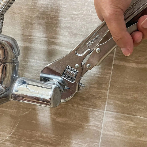 10 Inch Locking Adjustable Wrench With Quick Release And Inch Metric Scale Rust Resistant Precision Machined Jaw And Worm Gear Drop Forged Carbon Steel For Auto Repair Plumbing And DIY Maintenance 2.7 X 0.75 Inch being used to grip a plumbing fixture.