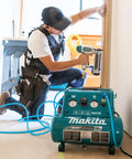 Kickass Quiet Electric Air Compressor, 1 Horsepower 2 Gallon Tank, used by contractor with nail gun in job site.