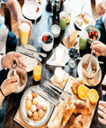 People using Six Piece Mini Ice Tongs Set 4.25 Inch Stainless Steel Tiny Serving Tongs at a breakfast table with pastries and fruits.