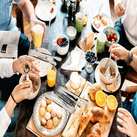 People using Six Piece Mini Ice Tongs Set 4.25 Inch Stainless Steel Tiny Serving Tongs at a breakfast table with pastries and fruits.