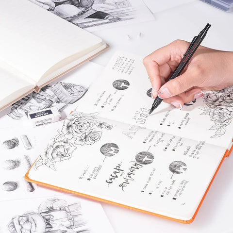 Hand using metal mechanical pencil for drawing in a sketchbook, visible sketches and erasers, Metal Mechanical Pencil Set With Case For Drawing And Sketching, Six Pencils In 0.5, 0.7, 0.9, And 2.0mm, Lead Holders, Twenty Refills 6B 4B 2B HB 2H 4H, Erasers, Sharpener, Kneaded Eraser, For Artists And Doodlers.