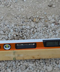 Digital Box Level 24 Inch With High Accuracy Plus 0.1 Degree Readout on wood, orange tool for carpentry and masonry, job site use.