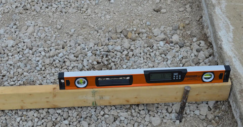 Digital Box Level 24 Inch With High Accuracy Plus 0.1 Degree Readout on wood, orange tool for carpentry and masonry, job site use.