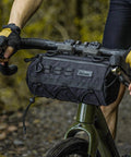 Cyclist using 2.8L Waterproof Front Tube Bag For Road Gravel And Mountain Bikes, Cylindrical EVA Frame Pack, mounted on handlebars