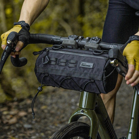 Cyclist using 2.8L Waterproof Front Tube Bag For Road Gravel And Mountain Bikes, Cylindrical EVA Frame Pack, mounted on handlebars