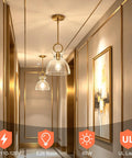 Super Sleek Brushed Gold Pendant Light For Kitchen Island Featuring Fully Adjustable Hanging Cord And Large Clear Glass Shade Creating A Lowkey Modern Vibe For Dining Room Decor in a stylish hallway.