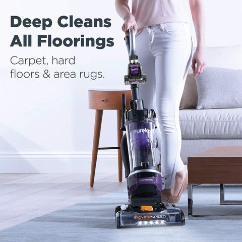 Front-right view of a purple Eureka PowerSpeed upright vacuum cleaner in use on a blue rug.